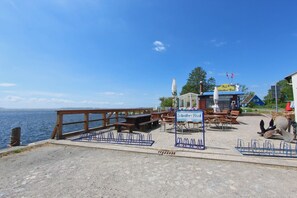 A waterfront restaurant with outdoor seating and a view of the sea. - Waterfront house with terrace and garden - Ferienhaus Storchennest Haus R - (Wiek)