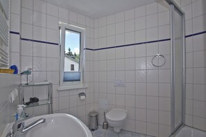 A bathroom with a bathtub, toilet, and shower. - 2-room vacation apartment with sea view from the balcony - Villa Vilmblick FeWo 15 - Villa (Putbus)