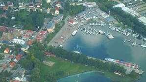 An aerial view of a marina with boats, a dock, and surrounding buildings.