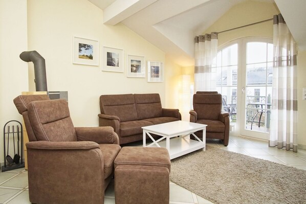 A living room with a sofa set, a coffee table, and a fireplace.