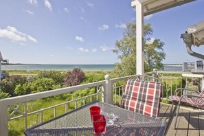 A balcony with a table and chairs, overlooking a beach and ocean. - Directly behind the dune, with balcony and sea view - Strandvilla Böck FeWo 15 - (Glowe)
