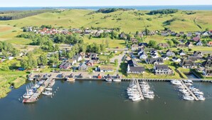 A coastal village with houses, a marina, and boats.