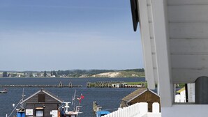 A coastal view with a wooden building, a dock, and a clear sky.