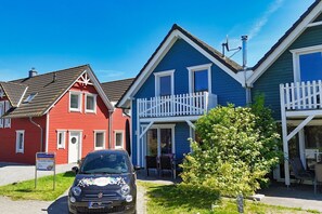 Une rangée de maisons aux couleurs vives, avec une voiture garée devant.