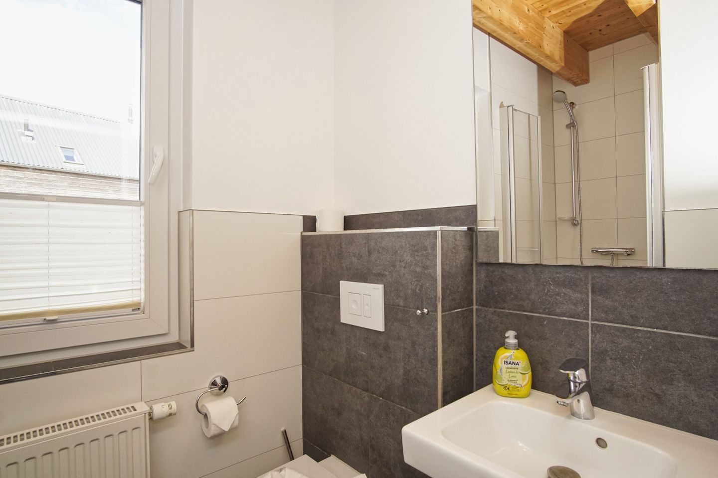 Ein Badezimmer mit Fenster, Waschbecken und Dusche.
