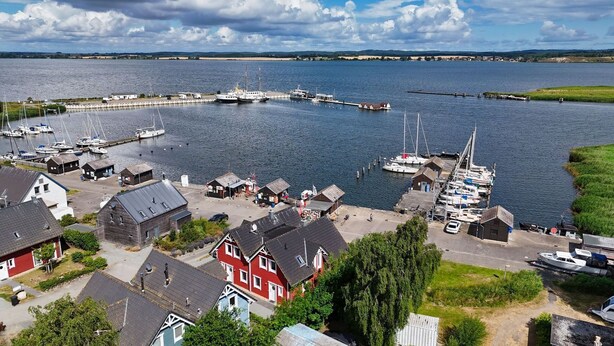 Un village côtier doté d’un port de plaisance, de maisons et d’un quai.