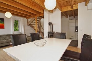 A modern kitchen with a central island, wooden ceiling beams, and a staircase leading to an upper level. - Vacation home close to the harbor with terrace and sea view - Holiday home TimpeTe Starboard (Gager)