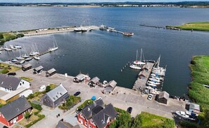 An aerial view of a marina with boats docked, a pier extending into the water, and buildings along the waterfront. - Vacation home close to the harbor with terrace and sea view - Holiday home TimpeTe Starboard (Gager)