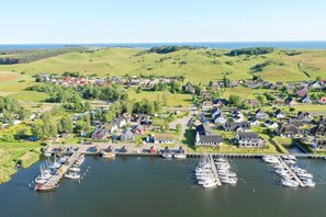 Ein Küstendorf mit Häusern, einem Jachthafen und Booten.