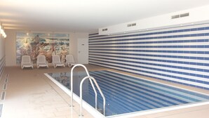 A swimming pool with a tiled wall, a door, and a mural on the wall. - Near the beach, vacation apartment with sauna and swimming pool - Strandr.BaabeFeWo1.29 (Baabe)