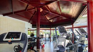 Uma academia com esteiras, elípticos e equipamentos de musculação.