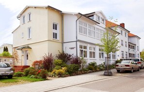 A two-story residential building with a beige facade and white trim.