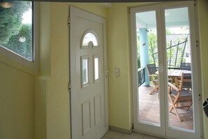 A door leading to a covered patio with a table and chairs.