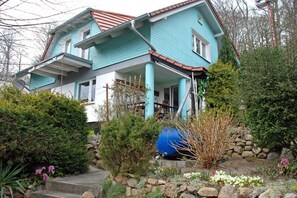 A two-story house with a blue exterior and a red roof.