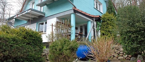 A two-story house with a blue exterior and a red roof.