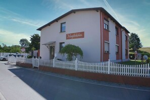 Un edificio de dos pisos con un letrero que dice 'Maiglöckchen' en la fachada.