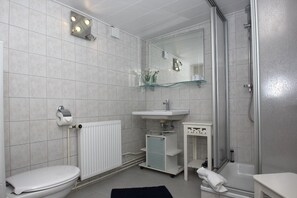 A modern bathroom with a toilet, sink, and shower. - Haus Maiglöckchen F-1016 Wohnung 03 - F-1016 Haus Maiglöckchen (Göhren)