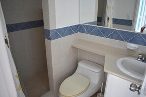 Bathroom features a toilet, sink, and mirror in a simple, clean design.