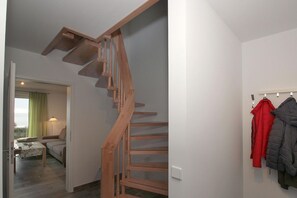 Eine Holztreppe in einem Raum mit Blick ins Freie.