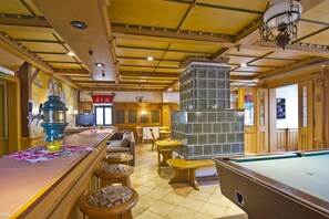 A bar area with a pool table, bar stools, a coffee machine, and a fireplace. - F-1065 Brunnenaue - Brunnenaue Group Home F-1065 (Sagard)
