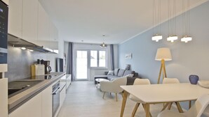 Une cuisine moderne avec un coin repas, un canapé et une lampe.
