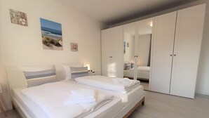 Una camera da letto moderna con un letto grande, un armadio e un comodino.