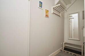 A hallway with a white door, a small window, and a wall-mounted towel rack.