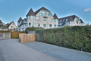 A residential building with multiple levels, a gated entrance, and a paved driveway. - Domizil Strandburg Appartement 08 - Domizil Strandburg (Timmendorfer Strand)