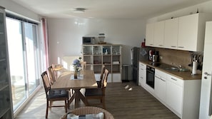 Eine moderne Küche mit weißen Schränken, einem Holzespeisetisch und einem eingebauten Backofen.