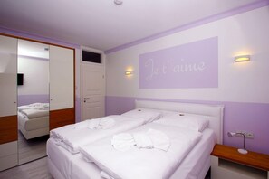A bedroom with a double bed, a mirror, a door, and a wall with a light fixture and a sign that says "Je t'aime". - Close to the beach, balcony, ocean view, sauna, free adventure pool - Palstek Beach House - (Göhren)