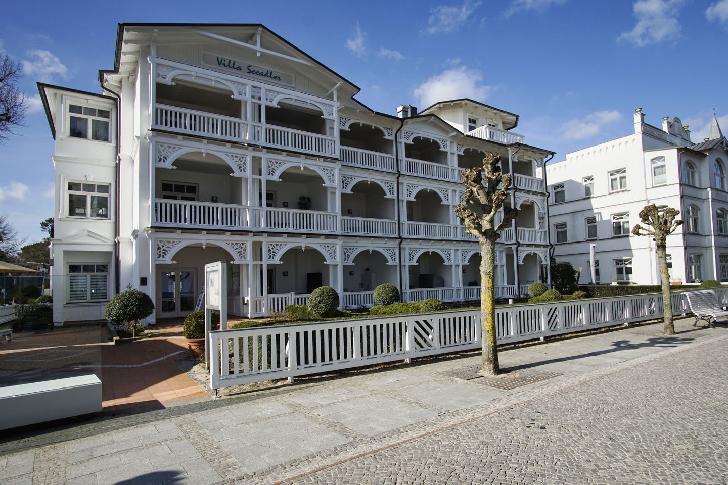 A multi-story building with balconies and a sign reading "Villa Secadler".