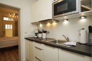 A modern kitchen with a built-in microwave, a coffee maker, and a sink.