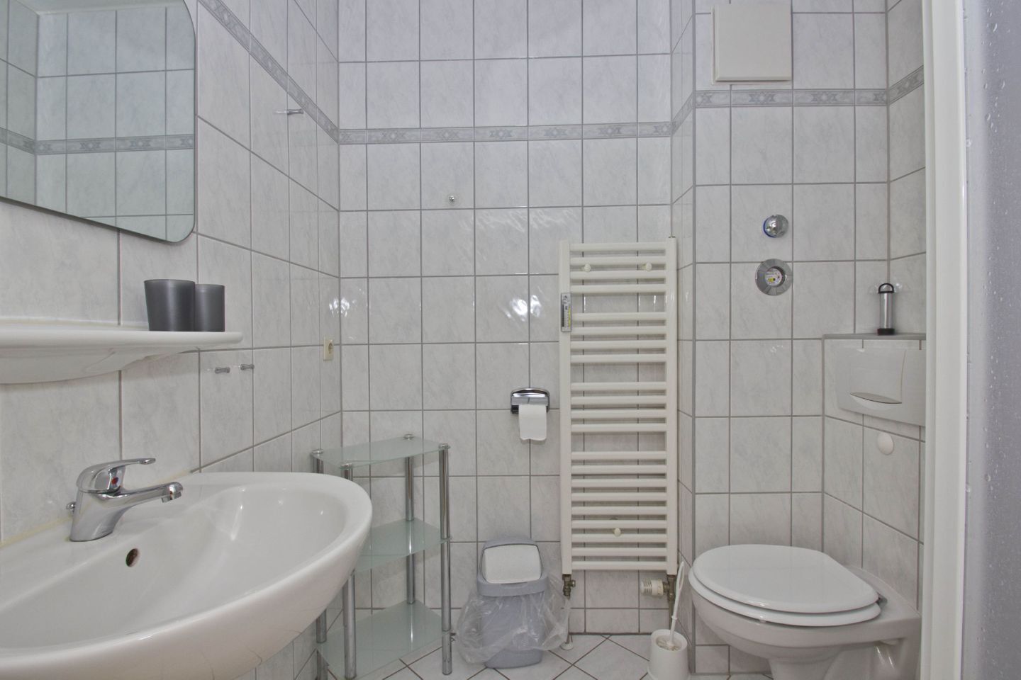 Un bagno con lavandino, WC e portasciugamani.