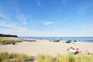 A beach with rows of beach umbrellas and boats, indicating a beach resort setting.