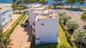 A modern building with a rooftop terrace, a parking area, and a view of the sea. - Oratge Beach Views by Interhome (Port Pollença)