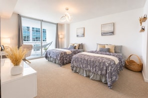 Une chambre moderne avec deux lits, une grande fenêtre et un balcon.