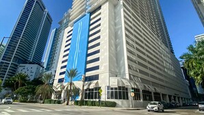 A tall, modern skyscraper with a distinctive blue and white facade, surrounded by other high-rise buildings. - 4 bed boho condo with amazing view *Comfortable, stylish and clean* (Miami)