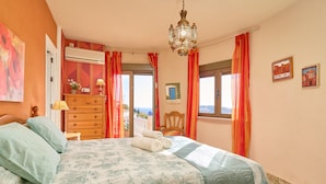 A bedroom with a bed, dresser, and a view of the outside. - "Villa María" with Sea View, Garden, Balcony & Wi-Fi (Almunecar)
