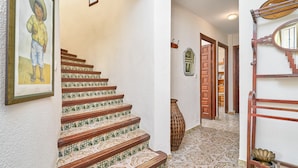 A staircase with patterned tiles, a framed picture on the wall, and a decorative mirror. - "Villa María" with Sea View, Garden, Balcony & Wi-Fi (Almunecar)