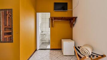 Uma casa de banho compacta com chuveiro, sanita e lavatório.
