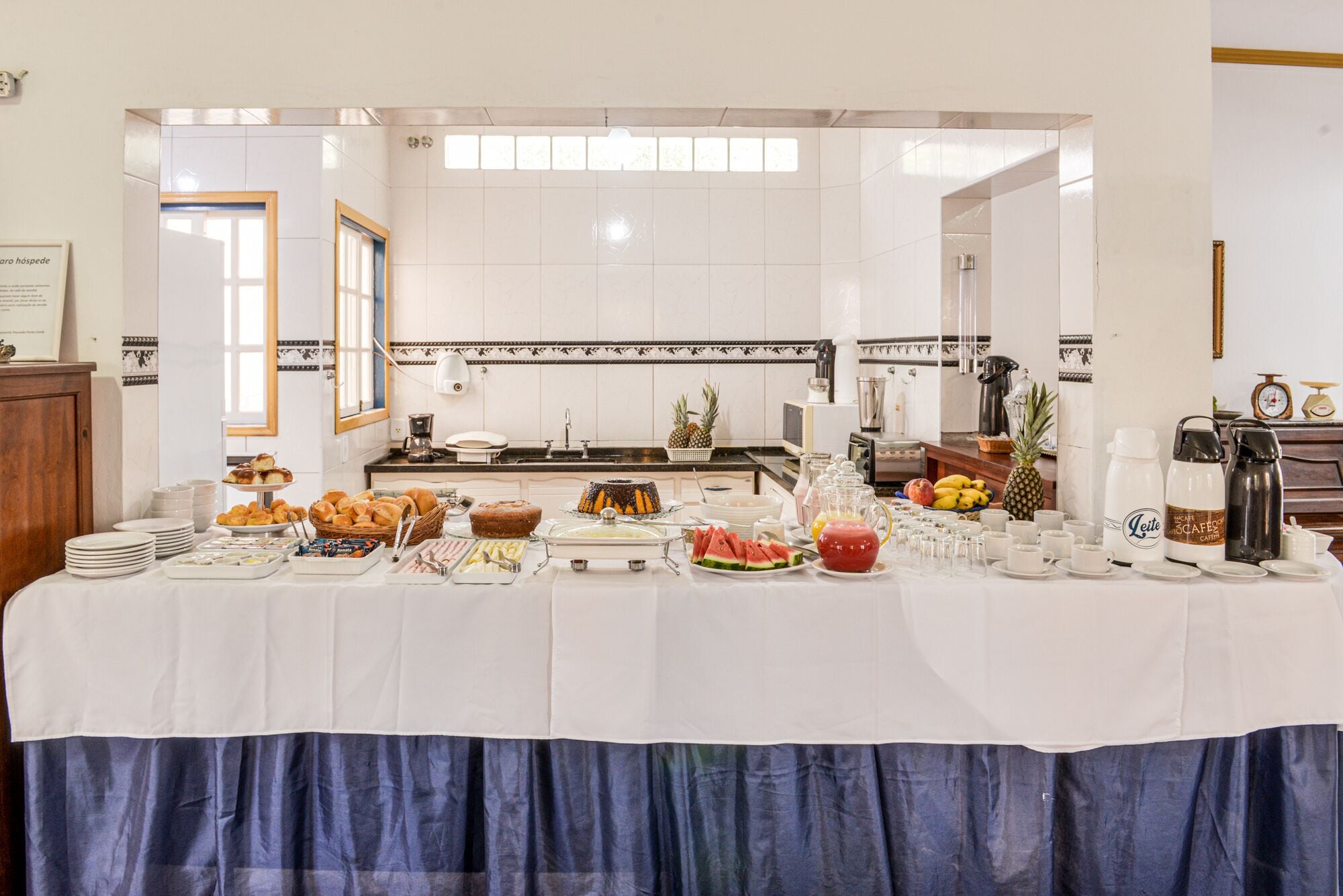 Un buffet proposant une variété de plats et de boissons, notamment des fruits, des pâtisseries et un gâteau.