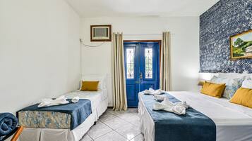 Una habitación de hotel con dos camas, una puerta azul y un cuadro en la pared.