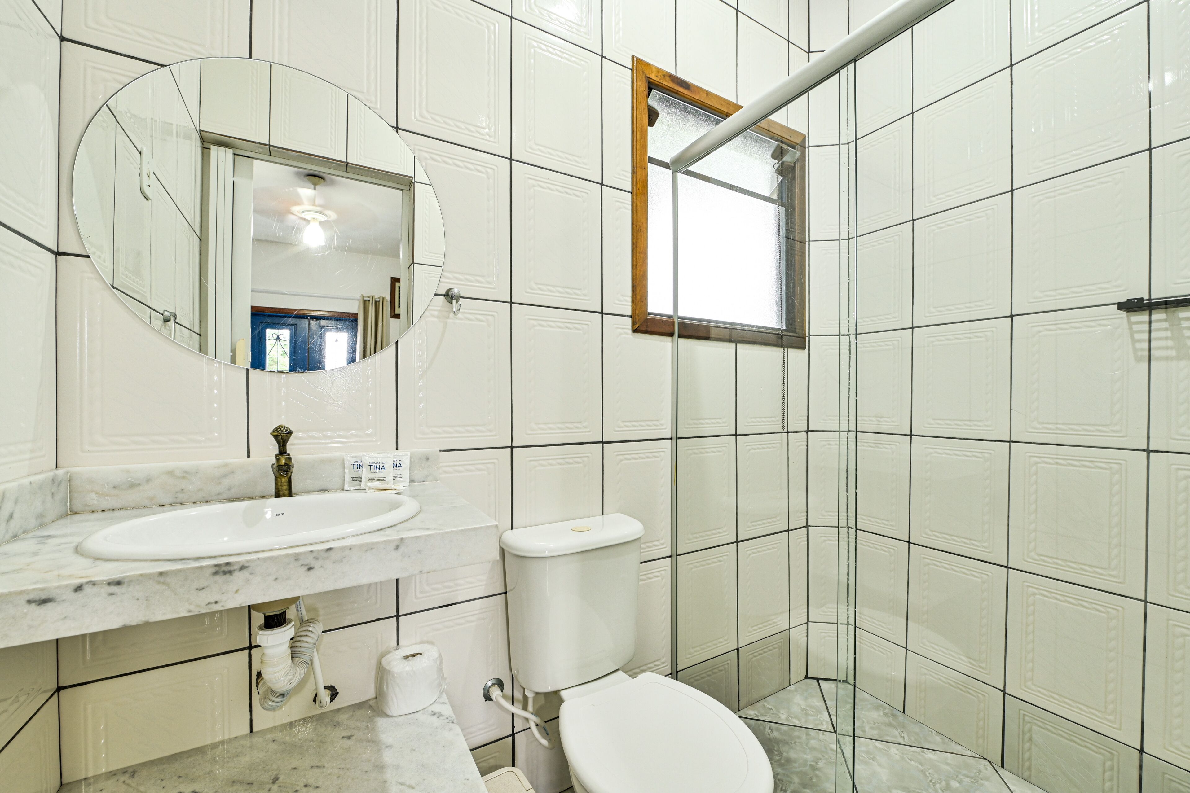 A bathroom with a white sink, toilet, and mirror.