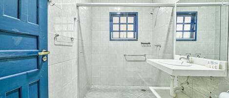 Une salle de bain avec une douche, un lavabo et un miroir.