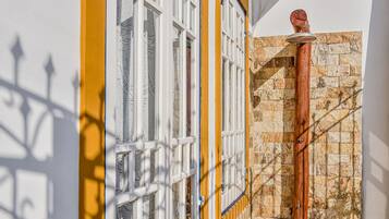 Une porte d’entrée avec un cadre jaune, une porte blanche et un mur en pierre.