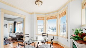 A corner room with a round glass table, four chairs, a sofa, and large windows with blinds. - Lakewalk House, near Lake Superior's North Shore and more! (Permit#PL 20140) (Duluth)