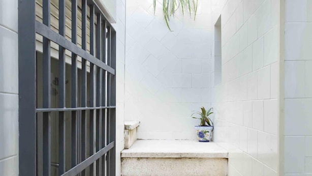 A narrow stairway with a potted plant on the landing. - Apartment 2 rooms-terrace Seville/Triana (Sevilla)