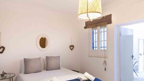 A bedroom with a bed, a round mirror, a window, and a door leading to another room. - Apartment 2 rooms-terrace Seville/Triana (Sevilla)