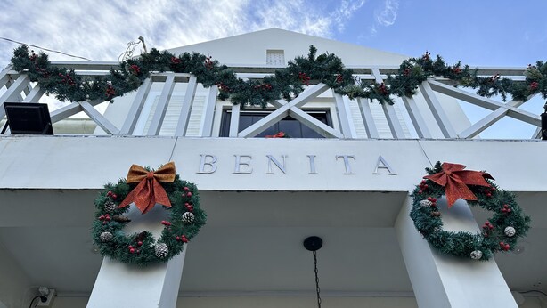 A building with the name 'BENITA' on the facade, decorated with Christmas wreaths and lights.