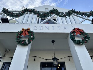 A building with the name 'BENITA' on the facade, decorated with Christmas wreaths and lights.